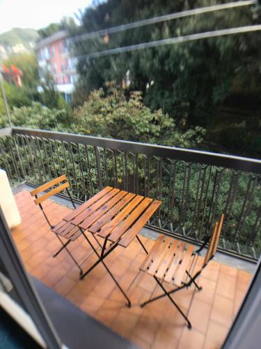 two chairs and a wooden table on a balcony at Appartamento del Golf - Secured Parking - in Rapallo