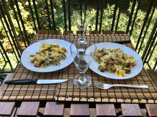 a table with two plates of food and a wine glass at Appartamento del Golf - Secured Parking - in Rapallo