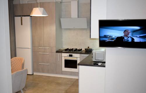 a kitchen with a flat screen tv on a wall at Apartment on Volodymyra Stelmakha 1b in Rivne