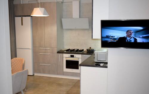 cocina con TV de pantalla plana en la pared en Apartment on Volodymyra Stelmakha 1b, en Rivne