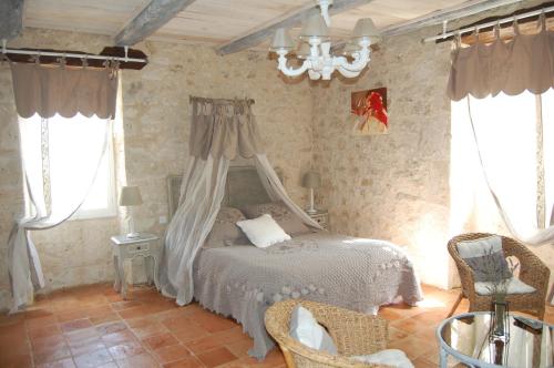 TouffaillesにあるMaison d'hôte Lapiadeのベッドルーム(天蓋付きベッド1台付)