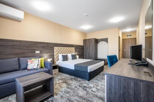 a hotel room with a bed and a couch at Plaza Hotel Plovdiv - Free Parking in Plovdiv