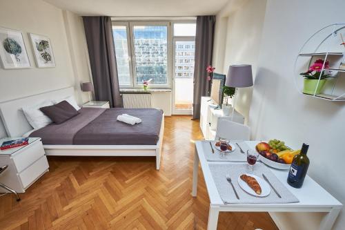 a small room with a bed and a table with food on it at Top Ten House Marszałkowska III in Warsaw