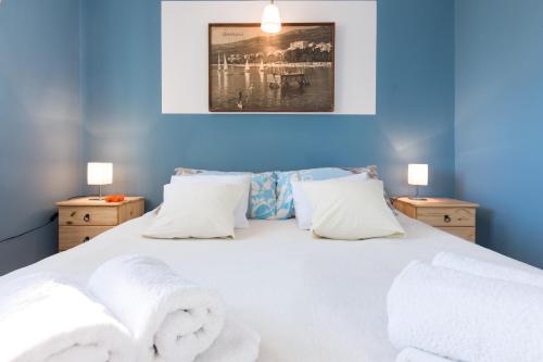 a bedroom with a white bed with towels on it at Holiday Home Adricon in Grižane