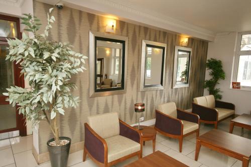 a waiting room with chairs and a potted plant at Best Western Thurrock Hotel in Grays Thurrock