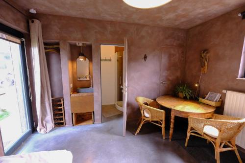 a room with a table and chairs and a bathroom at Maison d'Hôtes Cerf'titude in Érezée