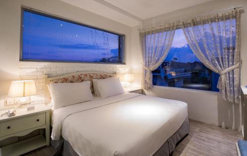 a bedroom with a large bed and a large window at Summerbird - Bed and Brasserie in Bandung