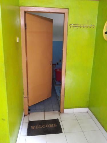 een deur naar een badkamer met groene muren bij Janti Transit Room Syariah in Yogyakarta