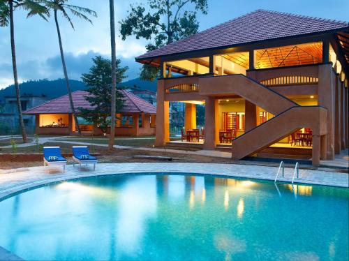a house with a swimming pool in front of a house at Abad Green Forest Thekkady in Thekkady