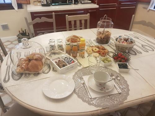 a white table with food and dishes on it at Perle d'Ambra in Lucca
