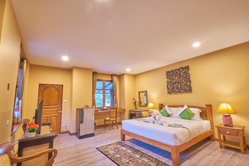 a bedroom with a bed and a living room at Mina Garden Villa Resort in Chiang Mai