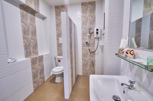 a bathroom with a white toilet and a sink at Mina Garden Villa Resort in Chiang Mai