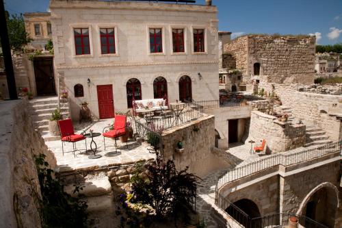 a house with two red chairs in front of it at Hezen Cave Hotel in Ortahisar