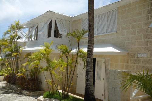 a white house with palm trees in front of it at Inchcape Seaside Villas in Christ Church