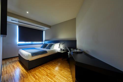 a bedroom with a bed and a desk and a window at Delparco Hotel in Buttrio