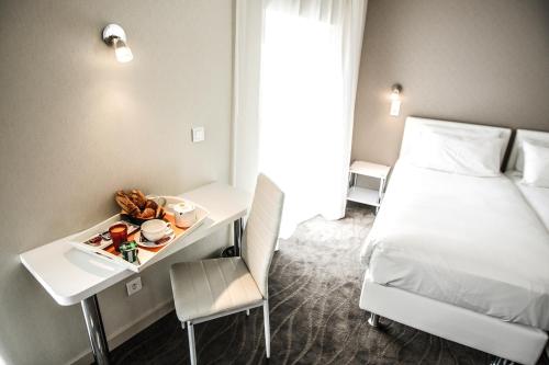 Ένα ή περισσότερα κρεβάτια σε δωμάτιο στο Hôtel Ligure