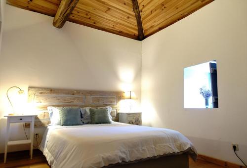 - une chambre avec un grand lit et une tête de lit en bois dans l'établissement Porto Natura House, à Valongo