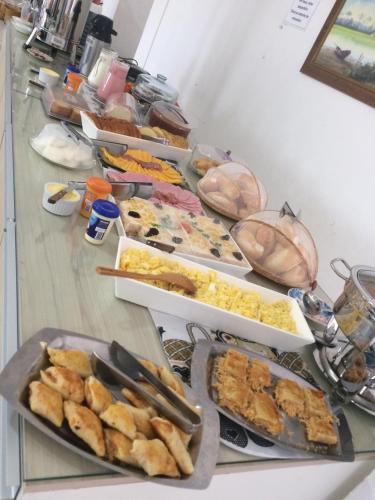 a table with many different types of food on it at Pousada Loft Praia dos Anjos in Arraial do Cabo