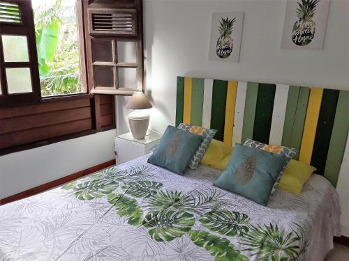 a bedroom with a bed with pillows and a window at Chez Karine & Harold in Sainte-Luce