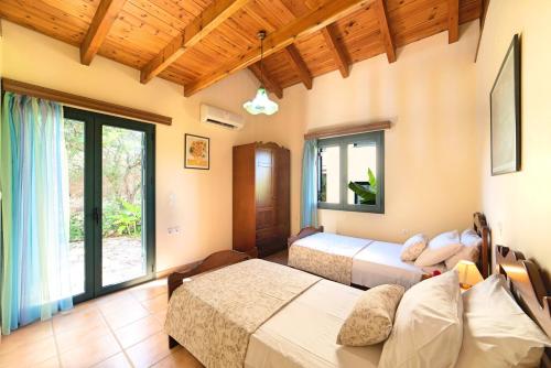1 dormitorio con 2 camas y ventana grande en Sentido Villas en Arménoi