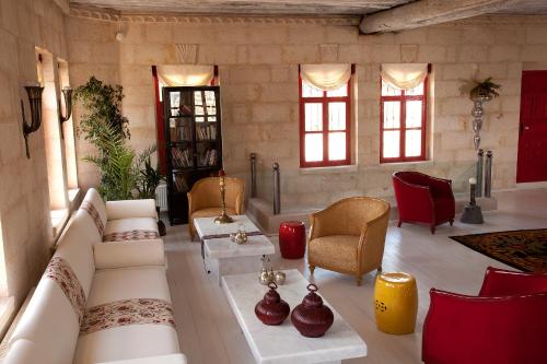 a living room with a couch and chairs and windows at Hezen Cave Hotel in Ortahisar