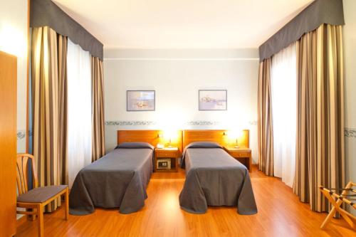 a hospital room with two beds in it at Hotel Terminus & Plaza in Pisa
