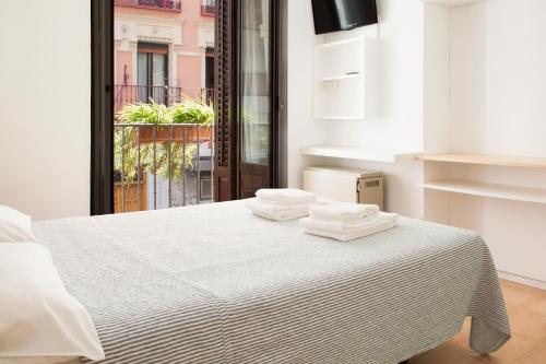 1 dormitorio con 1 cama con toallas en Hostal La Zona, en Madrid