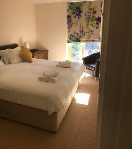a bedroom with a bed with towels on it at The Poltimore Inn in North Molton