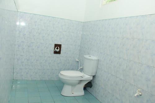 a bathroom with a white toilet in a room at Lobster Inn in Trincomalee