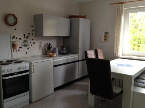 a kitchen with white appliances and a table and a window at Ferienwohnung Graupner in Schwarzenberg
