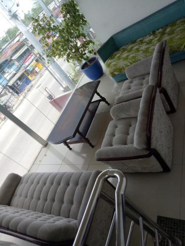 a living room with two chairs and a couch at BnT Inn in Mactan
