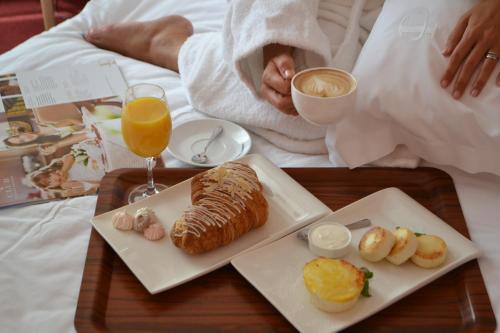 a tray with a breakfast of bread and orange juice at Aurora Premier Hotel in Kharkiv