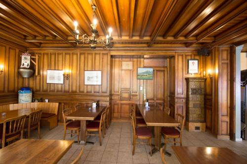 a restaurant with wooden walls and tables and chairs at Hôtel - Restaurant Le Manoir in Vaulruz