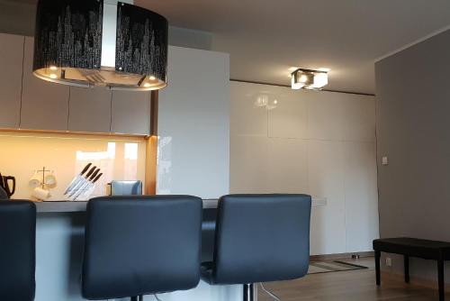 comedor con sillas azules y mesa en Apartament New York Różana 19, en Poznan