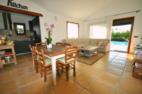 a kitchen and living room with a table and chairs at Capannizza Villas in Budoni