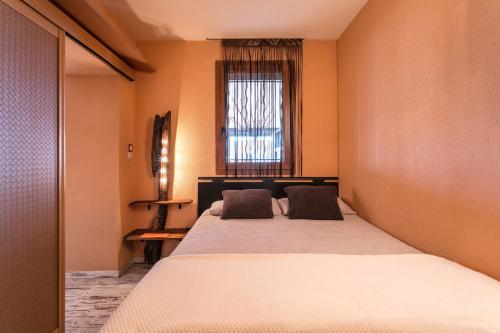 une chambre avec un grand lit et une fenêtre dans l'établissement Villa Naturiste Port Venus, au Cap d'Agde