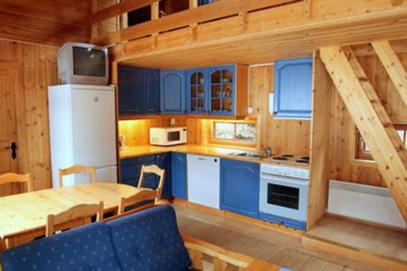 a kitchen with blue cabinets and a table in a cabin at Kvitfjell Alpinhytter Kvitfjellvegen 492 in Kvitfjell