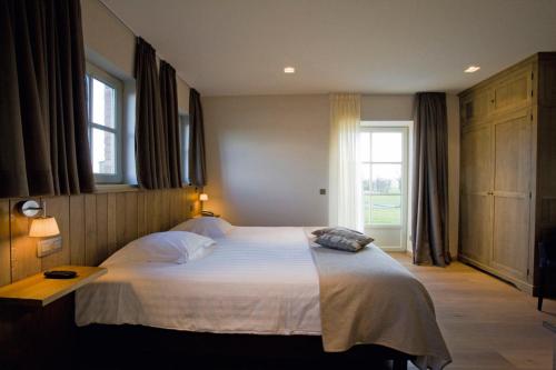 a bedroom with a large bed and a window at HuysHoeve in Knokke-Heist