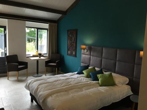 een slaapkamer met een groot bed met een blauwe muur bij Dunez men only resort in Drunen