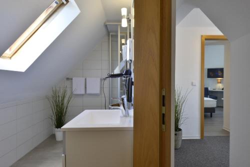 uma cozinha branca com um lavatório e uma janela em Landhaus Elbert em Rheinböllen