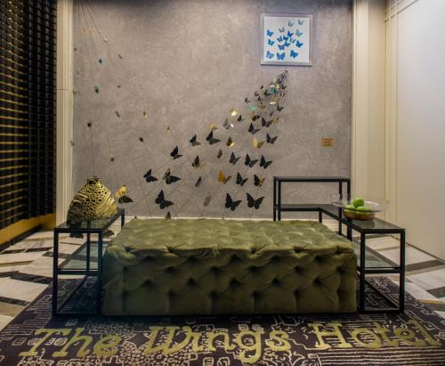 a living room with a bed, chair, and a painting on the wall at The Wings Hotel Istanbul in Istanbul