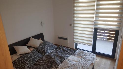 sypialnia z łóżkiem i oknem z żaluzjami w obiekcie Apartman Mir w mieście Zlatibor