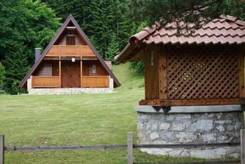 a log cabin in a field next to a fence at Vikendica Tarsko srce S in Mitrovac