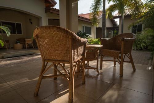 two wicker chairs and a table on a patio at Costa Esmeralda Village in Palm-Eagle Beach