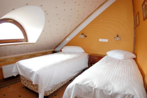 two beds in a room with an attic at Vecgulbenes muiža in Gulbene
