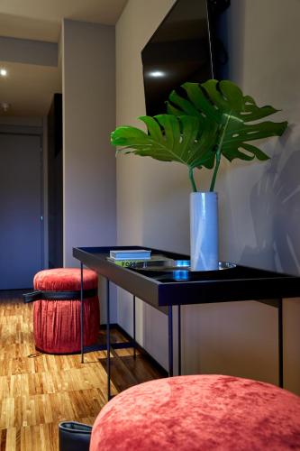 a black table with a plant on top of it at Delparco Hotel in Buttrio