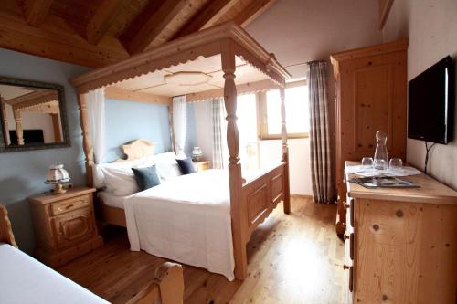 ein Schlafzimmer mit einem Bett und einem TV in einem Zimmer in der Unterkunft Chalet Melodie in Ehrwald