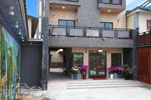 a building with a balcony and flowers in vases at Happy Inn in Yuchi