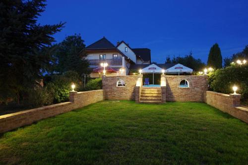 a house with lights in a yard at night at Vándor Vigadó in Zalaegerszeg