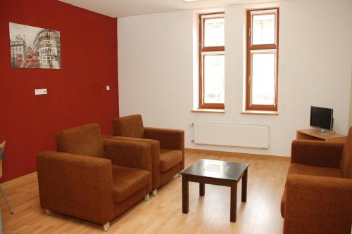 uma sala de espera com cadeiras e uma mesa de centro em Ośrodek Innowacja em Zabrze